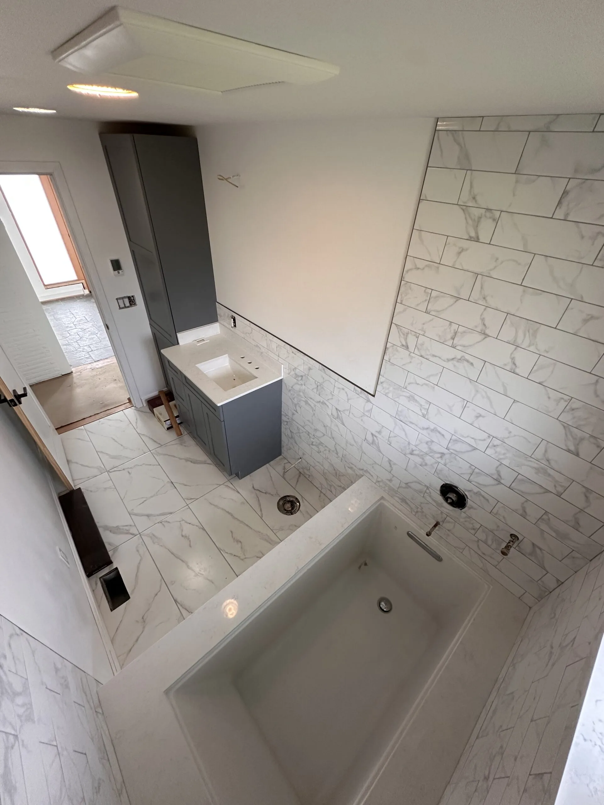 Modern kitchen — white shaker cabinets, marble backsplash, brass hardware